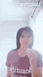 a woman in a purple t-shirt is making a funny face with her tongue out .