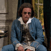 a man wearing sunglasses and a blue jacket is sitting down
