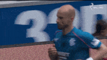 a man in a blue shirt with the number 30 on the back