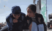 a man and a woman are sitting next to each other and the word mayward is on the bottom right
