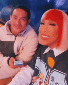 a man and a woman are sitting next to each other and smiling for a picture .