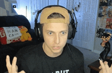 a man wearing headphones with a pillow that says little man cave