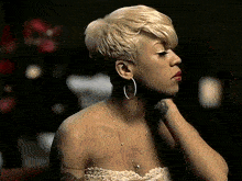 a woman with short blonde hair wearing hoop earrings and a white dress