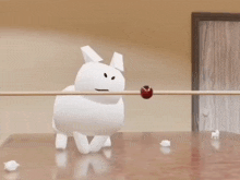 a white balloon is flying over a wooden table with a red ball on it .