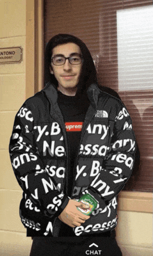 a man wearing a black jacket with supreme written on it