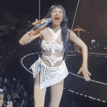 a woman singing into a microphone on stage
