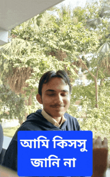 a man with his eyes closed behind a blue sign that says ' aami kissu jani na ' on it