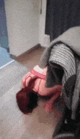 a woman with red hair is laying on the floor in a room
