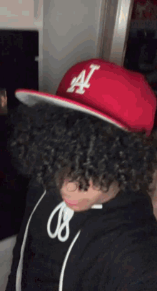 a person wearing a red la hat and a black shirt