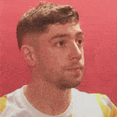 a close up of a man 's face against a red wall