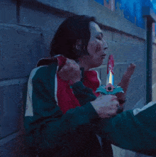 a man in a green jacket is holding a knife