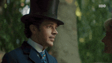 a woman wearing a pink hat is smiling in front of a man with hbo written in the corner