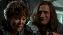 a man and a woman are standing next to each other and the woman is making a funny face