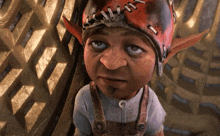 a cartoon character is wearing a red hat with stitching on it