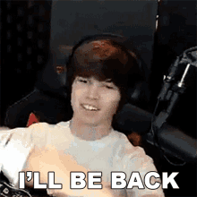 a man wearing headphones is smiling and says `` i 'll be back ''