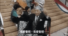 a man in a suit and tie is standing in front of a crowd and says i love leon