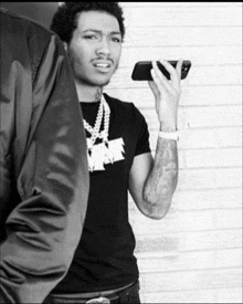 a black and white photo of a man holding a cellphone