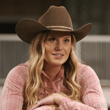 a woman wearing a cowboy hat and a plaid shirt with netflix on the bottom right