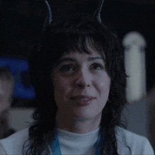 a woman with horns on her head is smiling and says good girl