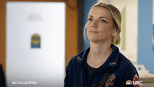 a woman wearing a chicago fire jacket looks up