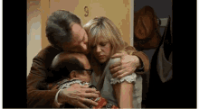 a man kisses a woman on the cheek while another man hugs a woman