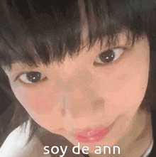 a close up of a girl 's face with the words soy de ann written on the bottom