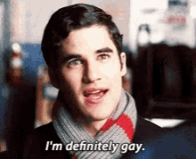 a man wearing a scarf and a suit says " i 'm definitely gay "
