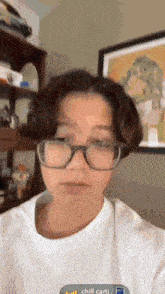 a person wearing glasses and a white shirt with the word chill on the bottom