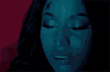 a close up of a woman 's face with her eyes closed and a blue background .