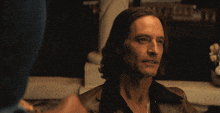 a man in a brown jacket looks up at something