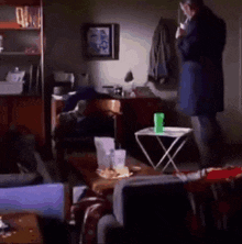 a man in a blue coat is standing in a living room