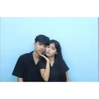 a boy and a girl are posing for a picture together .