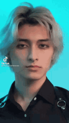 a close up of a young man 's face with a blue background