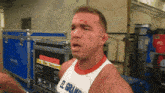 a man wearing a white tank top with el grand on it