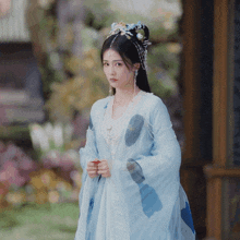 a woman in a blue and white dress with a crown on her head