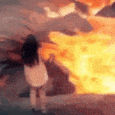 a woman is standing in front of a fire .