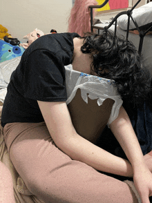 a person laying on a bed with a plastic bag over their head that says ' a ' on it