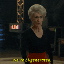 a woman says we 've bi-generated in a black shirt and red skirt