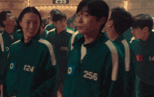 a group of people wearing green uniforms with numbers on them