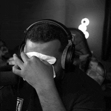 a man with headphones wipes his face with a napkin