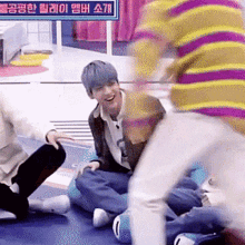 a group of people are sitting on the floor laughing and playing .