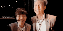 a couple of men are standing next to each other and smiling for the camera .
