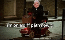 an elderly woman is riding a scooter with the caption i 'm on a diff path now