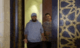 two men are standing in front of a door .