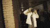 a woman in a white coat stands in a hallway
