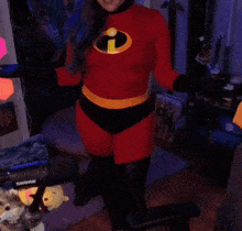 a woman in a red sweater is dancing in front of a poster for the incredibles
