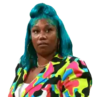 a woman with blue hair and a colorful jacket looks at the camera