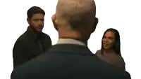 a man in a suit talks to two people