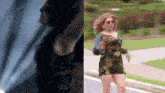 a woman in a floral dress is running down a street