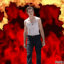 a man in a white tank top is standing in front of a red background with picmix written in the bottom right corner